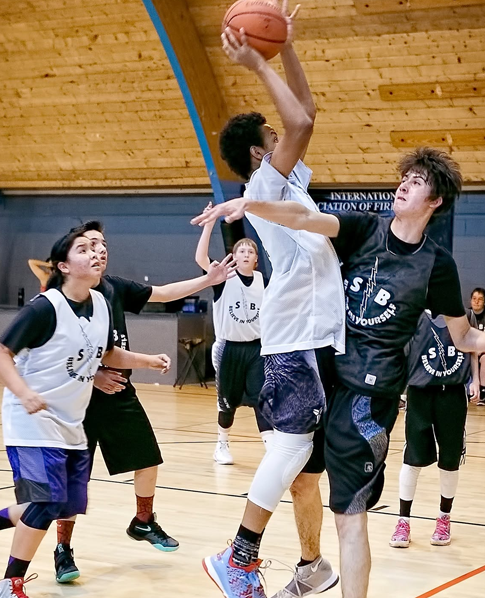Players competing for a rebound at a basketball camp